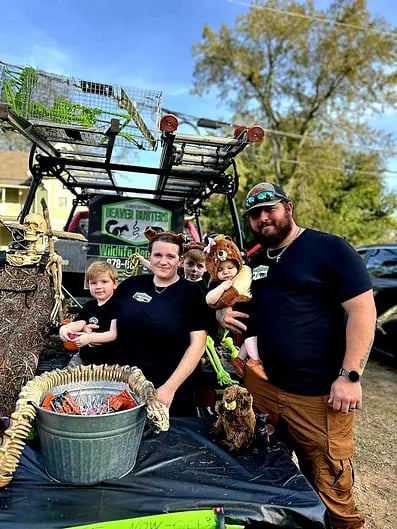 Family posing with reptiles and animals near wildlife rescue truck