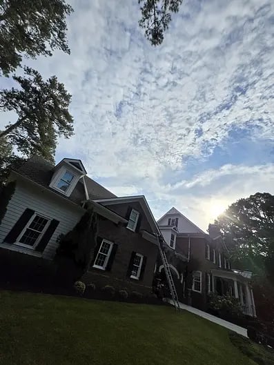 Residential houses under cloudy sky with ladder leaning against building